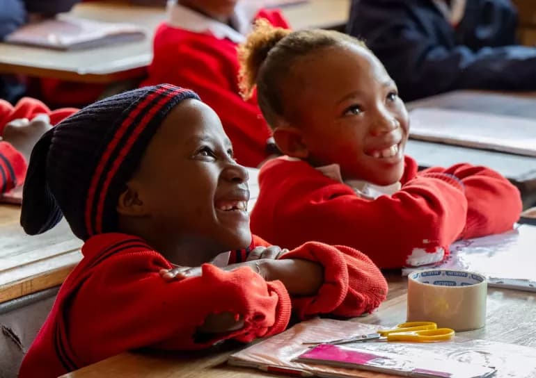 African teacher and young students in an early years classroom